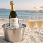Bottiglia di Francone Valsellera su ghiaccio in secchiello metallico con due flute di spumante in spiaggia